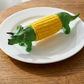 Soportes creativos para mazorcas de maíz con forma de dinosaurio